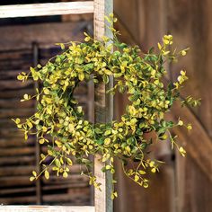 a wreath hanging on the side of an old wooden building with stairs in the background