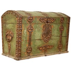 an old green trunk with ornate carvings on the front and sides, isolated against a white background