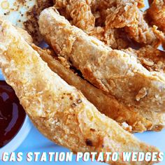 some fried food is on a plate with ketchup and sauce in the background