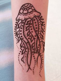 a woman's arm with a tattoo on it that looks like a jellyfish