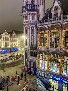 an aerial view of people walking around in the city at christmas time with lights on