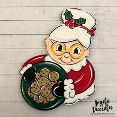 a santa clause holding a plate of cookies on a white background with wood planks