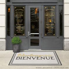 an entrance to a restaurant with large windows and gold lettering on the front door, along with a potted plant