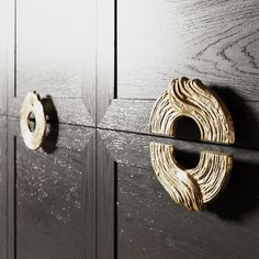 two wooden door handles are on the side of a gray cabinet with woodgrain