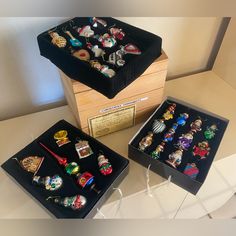 two boxes filled with lots of different types of pins on top of a white table