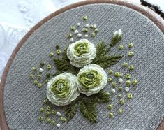 a close up of a embroidery on a piece of cloth with flowers in the center