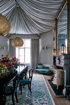 the dining room is decorated in blue and white with floral arrangements on the table top