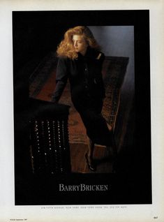 a woman leaning on a table in a black dress