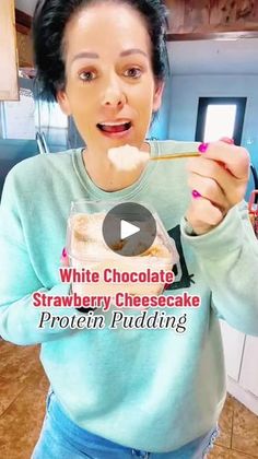 a woman holding a spoon in front of her mouth while she eats a chocolate strawberry cheesecake