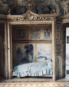 a bed in a room with paintings on the walls