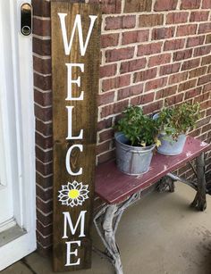 a wooden welcome sign sitting on top of a bench in front of a brick building