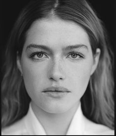 a black and white photo of a woman with freckled hair wearing a collared shirt