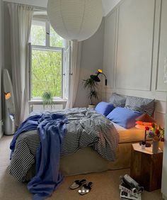 a bed room with a neatly made bed next to a window