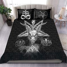 a bed covered in black and white sheets with an image of a goat on it