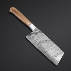 a large knife with a wooden handle on a black surface