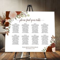 a table plan on a easel with flowers and greenery in the background, ready to be used as a wedding seating chart