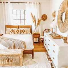 a bedroom with a bed, dresser and mirror on the wall next to a window