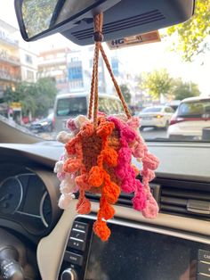 a car dashboard with a bunch of crocheted items hanging from the dash board