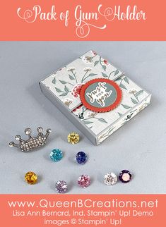 an open box with several different colored jewels in it and the words queen creations next to it