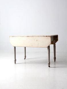 an old wooden bench sitting on top of a white floor