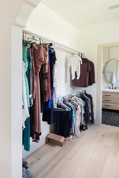 a closet with clothes hanging on the wall