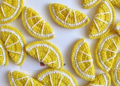 crocheted lemon slices are arranged on a white surface