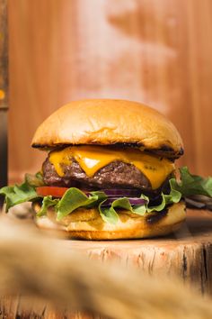 a cheeseburger with lettuce and tomato on a wooden table