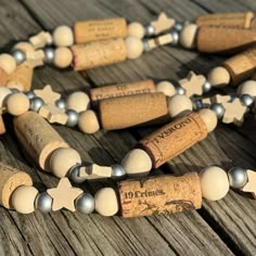 a necklace made out of wine corks and beads on a wooden table with other items