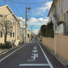 an empty street with chinese writing painted on the road and houses in the background,