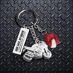 a motorcycle keychain with a red heart on it's front and side