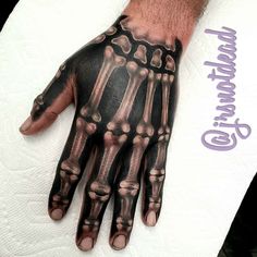 a man's hand with a skeleton tattoo on it