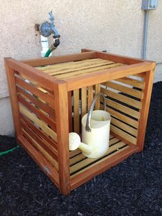 a wooden box with a watering can inside