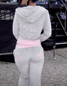 the back of a woman in grey sweatpants with pink stars on her hoodie