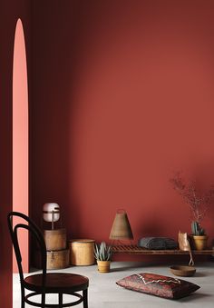 a room with red walls and various objects on the floor, including a wooden chair