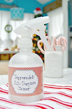 a bottle of peppermint all - purpose cleaner sitting on a table next to a jar of candy canes