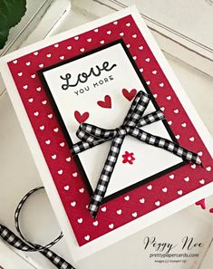 a close up of a card on a table with scissors and some flowers in the background