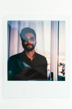 a polaroid photograph of a man in front of a window