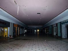 an empty building with tiled floors and doors on each side, looking towards the entrance