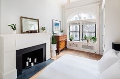 a bedroom with a fireplace and white walls