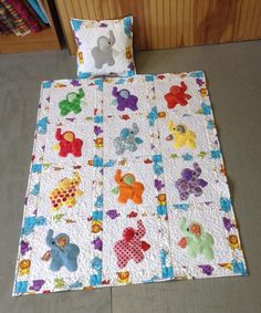 a child's quilted bed with teddy bears on it and two pillow cases