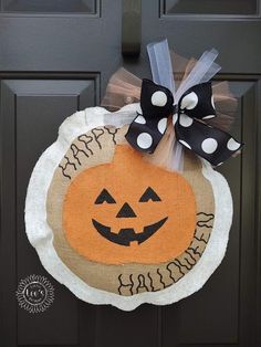 a door hanger decorated with a pumpkin and polka dot bow on the front door