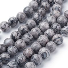 grey marble beads with white veining and black spots on the middle one strand is shown