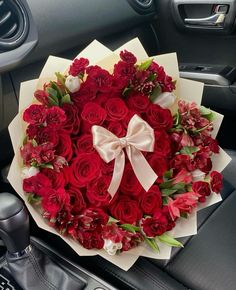 a bouquet of red roses in the center of a car