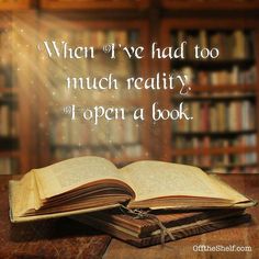 an open book sitting on top of a table in front of a bookshelf