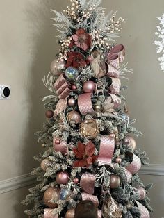 a decorated christmas tree with pink and silver ornaments