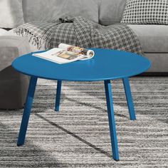 a blue coffee table sitting on top of a carpeted floor next to a couch