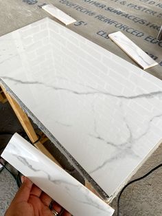 a person is holding a piece of white marble