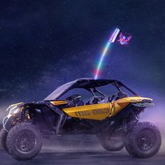 a yellow and black four - wheeled vehicle driving through the night sky