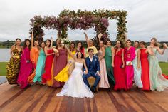 a group of people standing next to each other on a wooden platform with flowers in the background