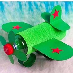 a green toy airplane with red stars on its wings and a bottle in the back